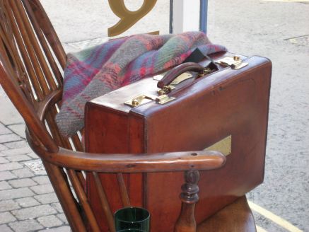 leather suitcase on 19thc windsor chair